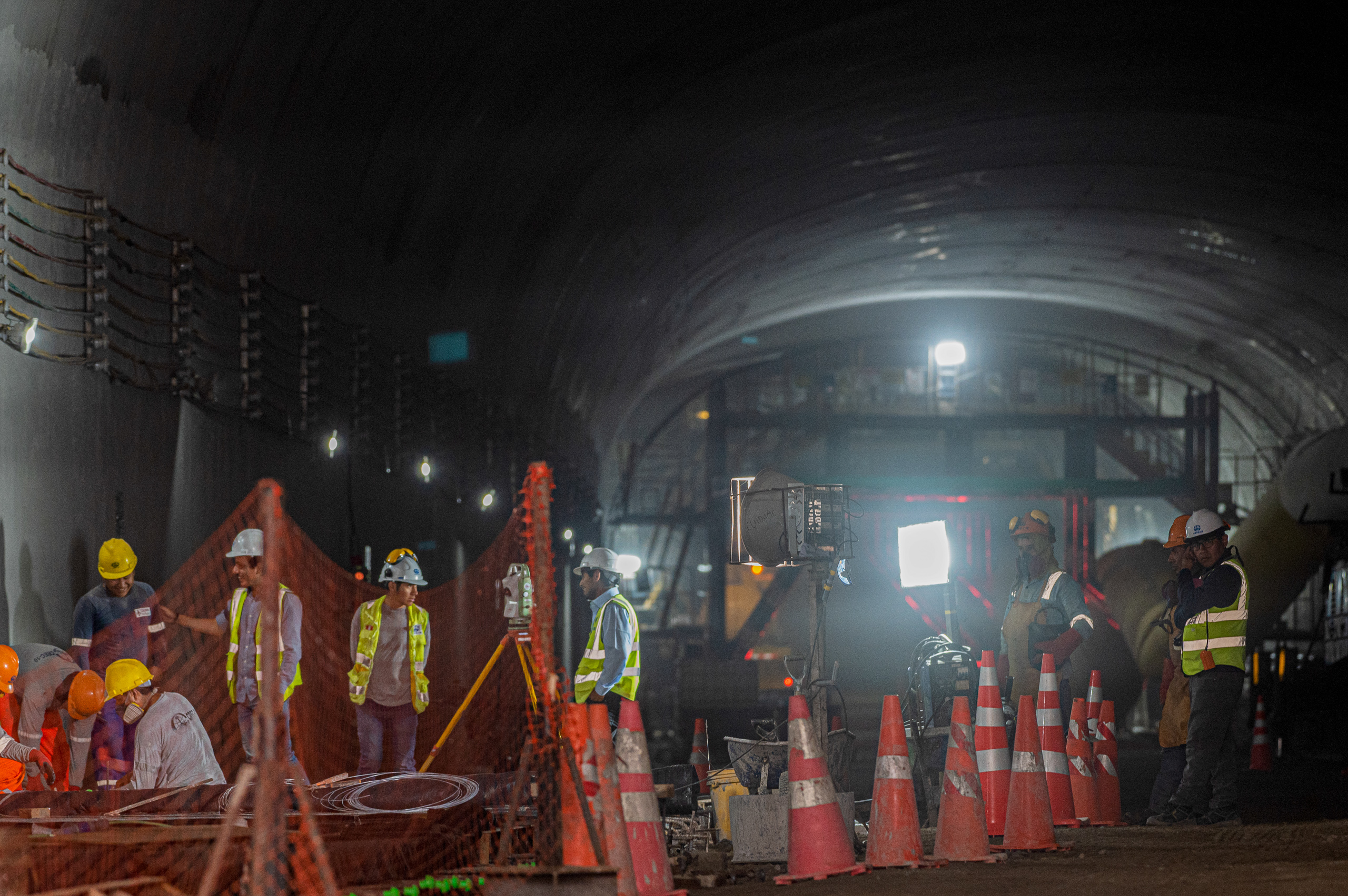 people wearing reflective clothes in dark tunnel