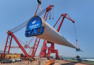 <p>Workers hoist a 123-metre wind turbine blade onto a ship in Lianyungang, Jiangsu province, in June this year (Image: Alamy)</p>