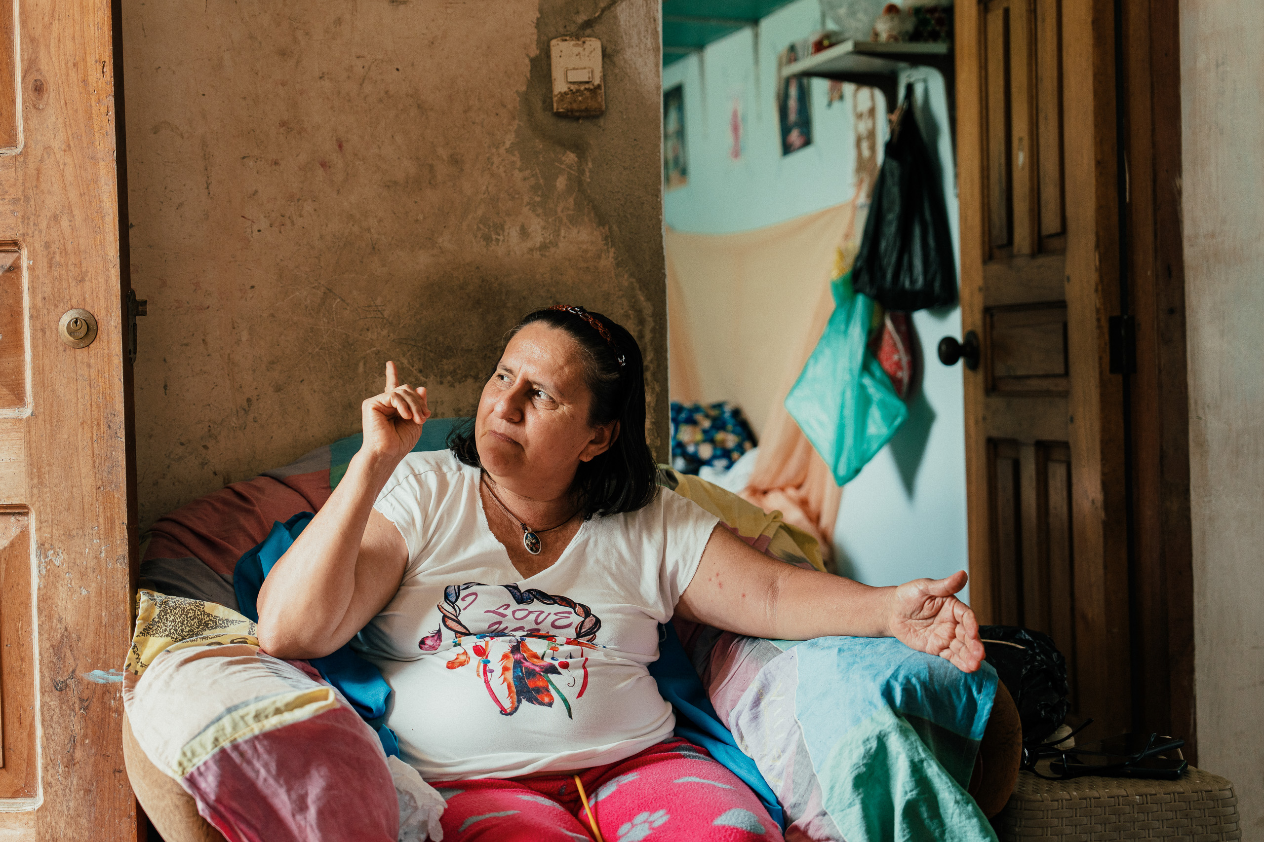 una mujer sentada señalando hacia arriba con su mano