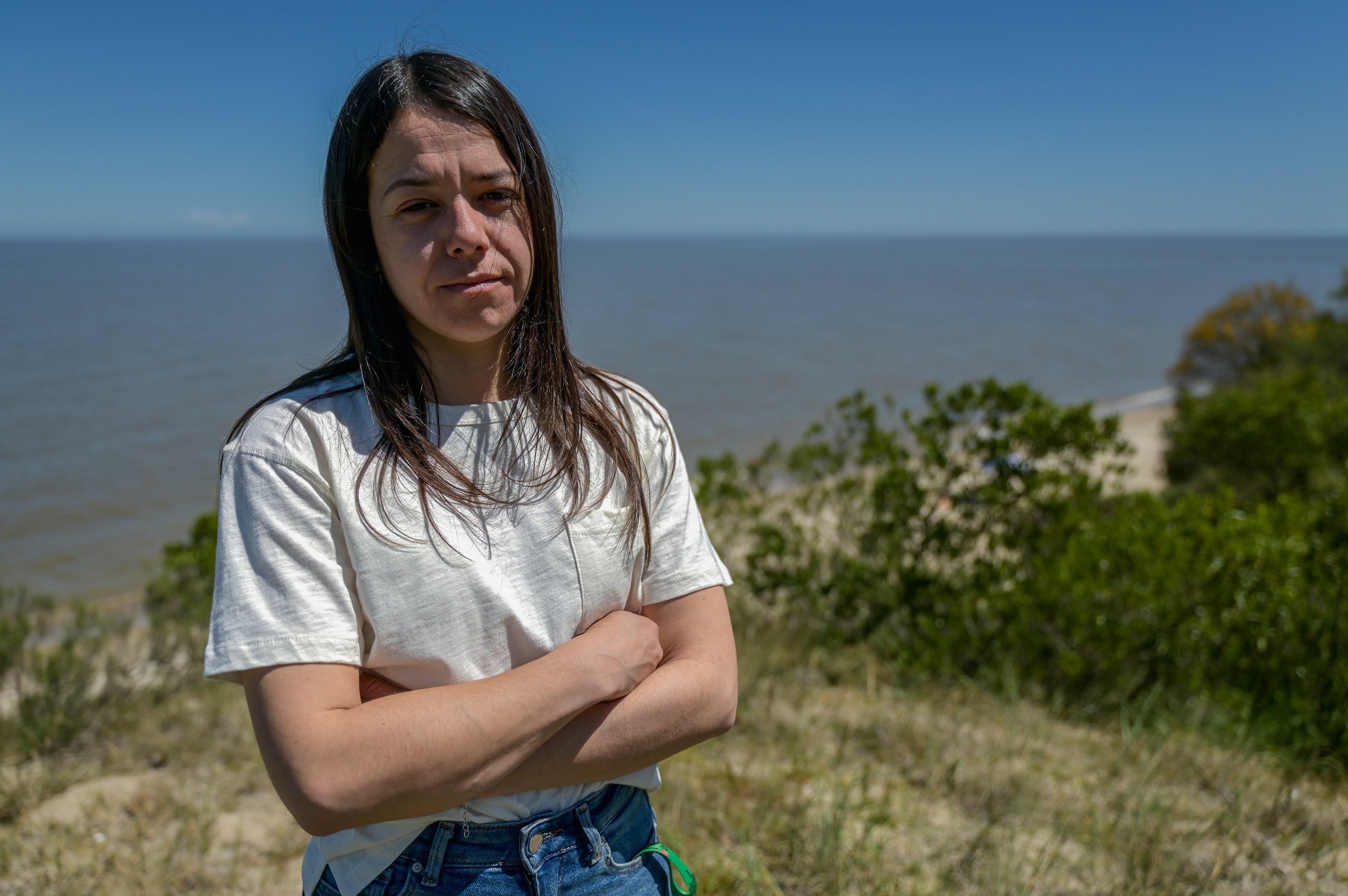 Woman with folded arms in front of a coastal view