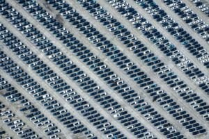 Bird's eye view of hundreds of cars in neat lines in a car park