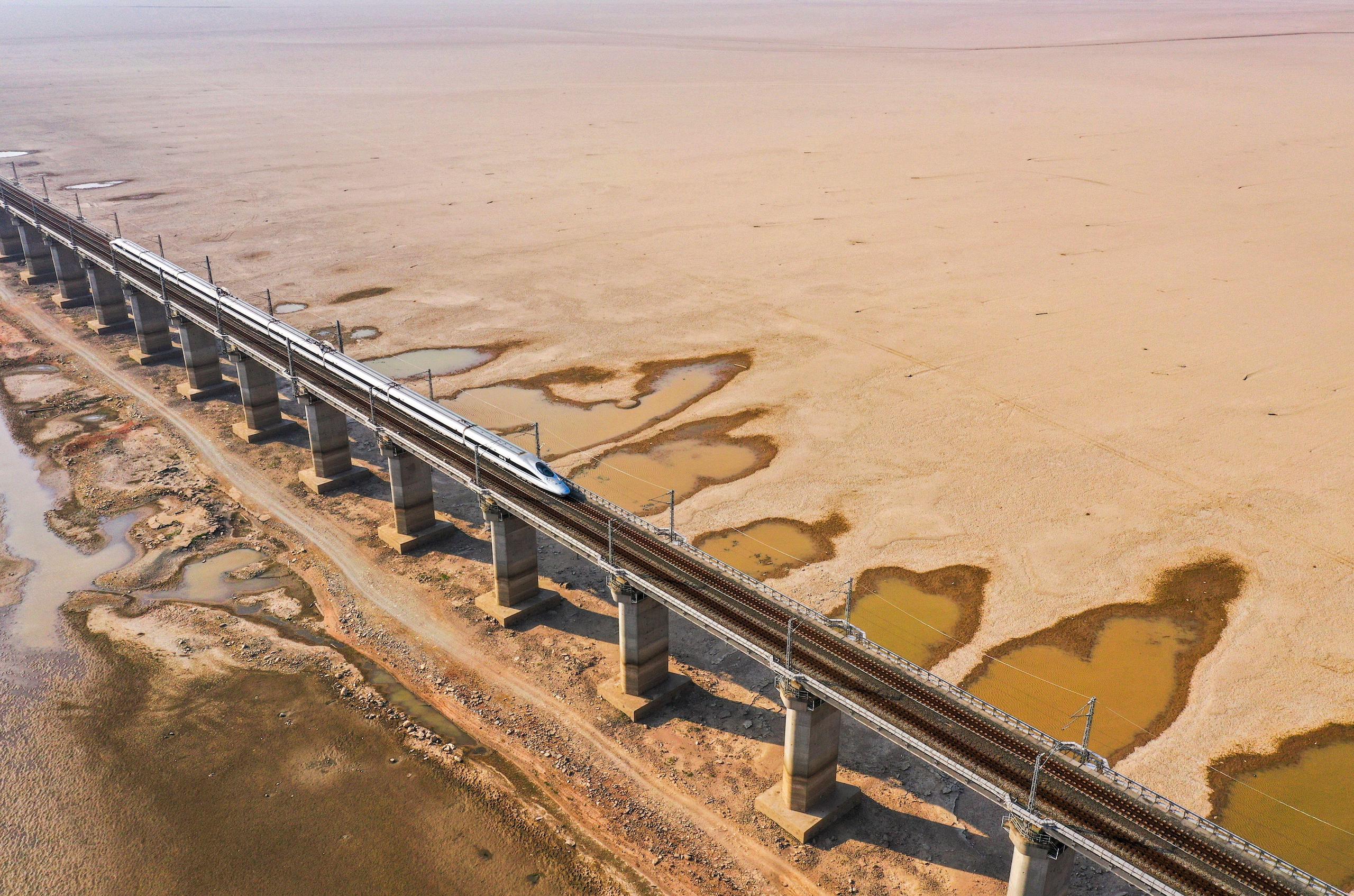 Train bridge crossing a dried-up lake