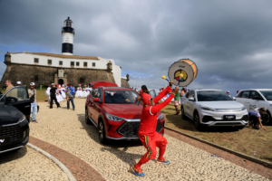 Un hombre vestido de rojo toca música en un acto de inauguración de una fábrica de automóviles eléctricos en Brasil