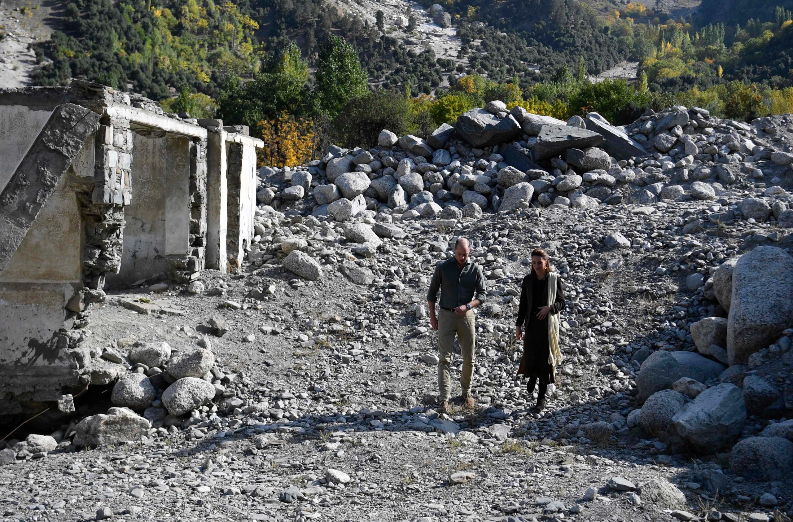 Prince and Princess of Wales walk amongst flood damaged ruins 