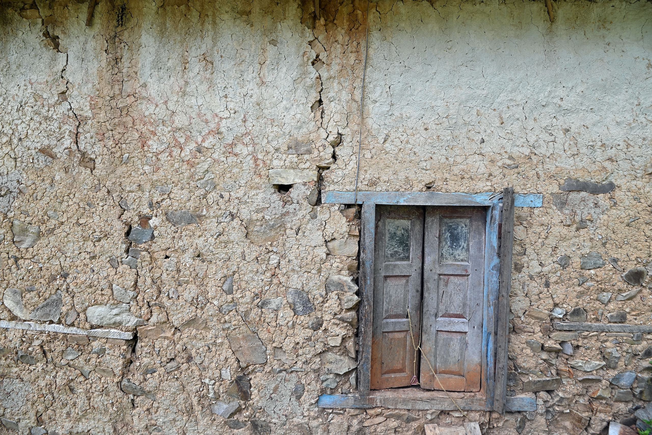 a window in a stone wall that cracks