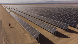 a staff working pass solar panels in a desert