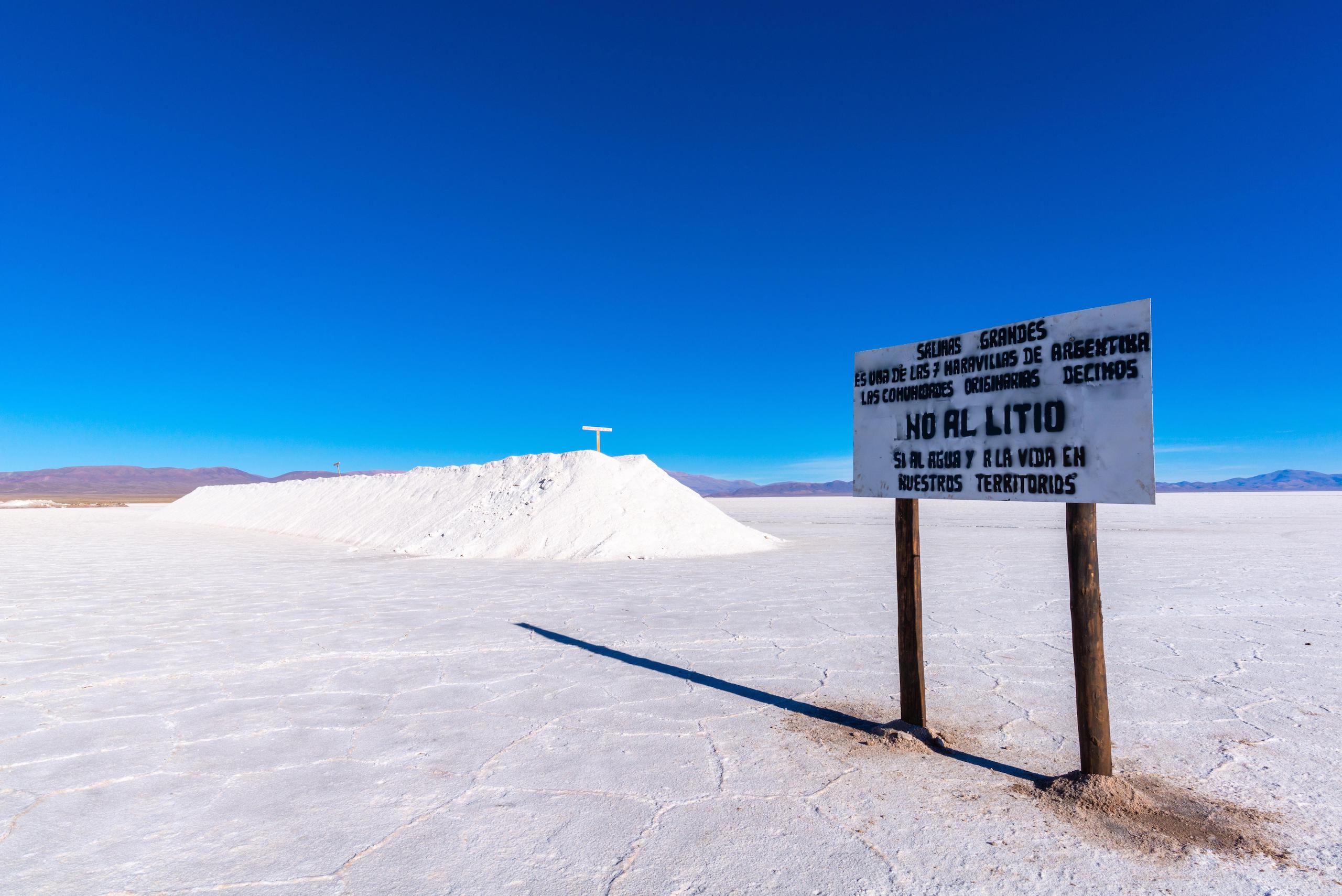 Letrero blanco en un salar, cielo azul intenso al fondo