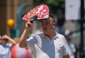 <p>2023年是有记录以来人类历史上最热一年。8月，一名游客试图用扇子遮挡重庆的骄阳。图片来源：Alamy</p>