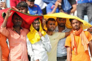 <p>Cricket fans cover their heads to save themselves from the heat during an Indian Premier League cricket match in Lucknow on 22 April (Image: Surjeet Yadav / Alamy)</p>