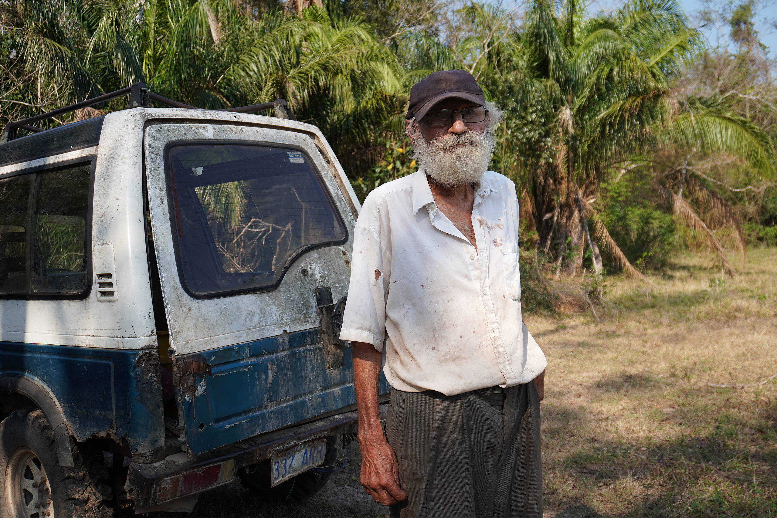a person standing next to a car in the woods