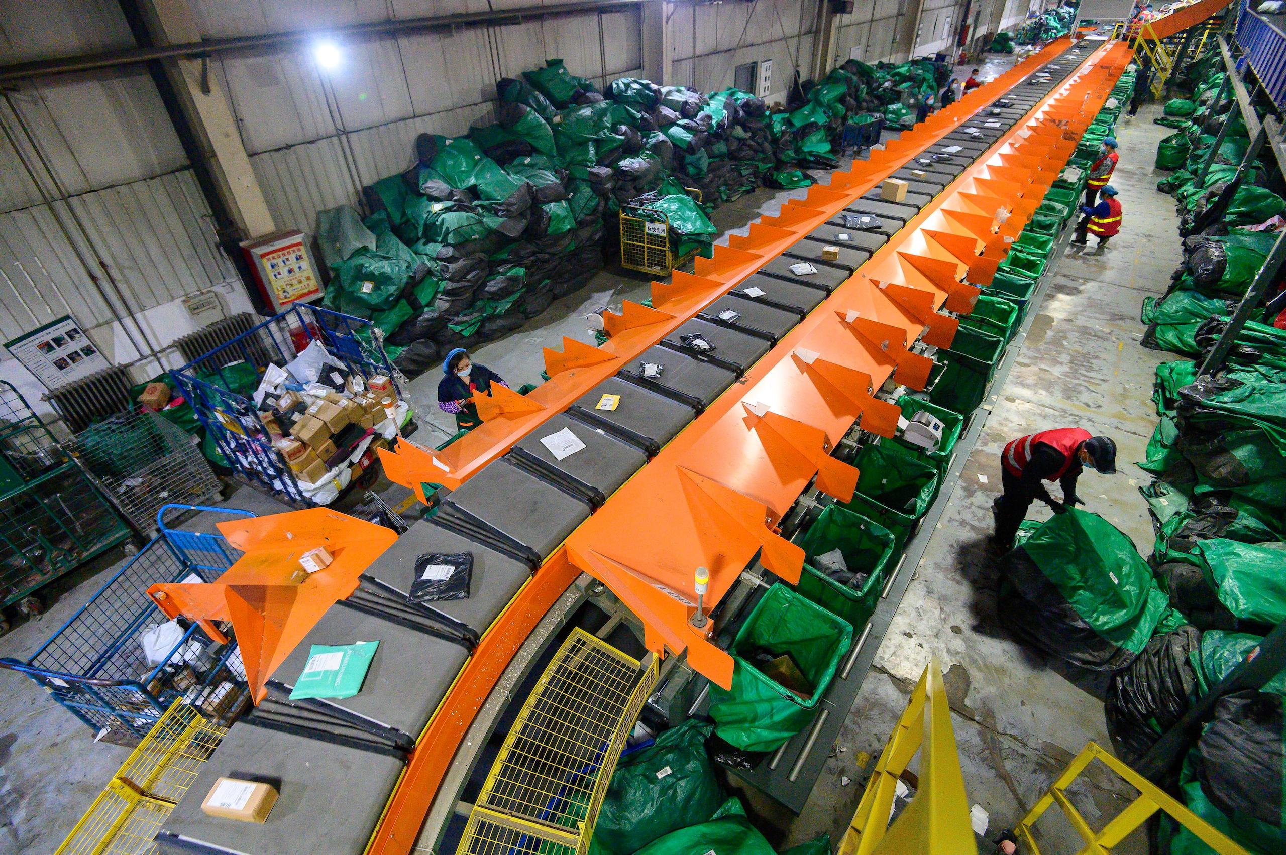workers sorting packages next to a conveyor belt