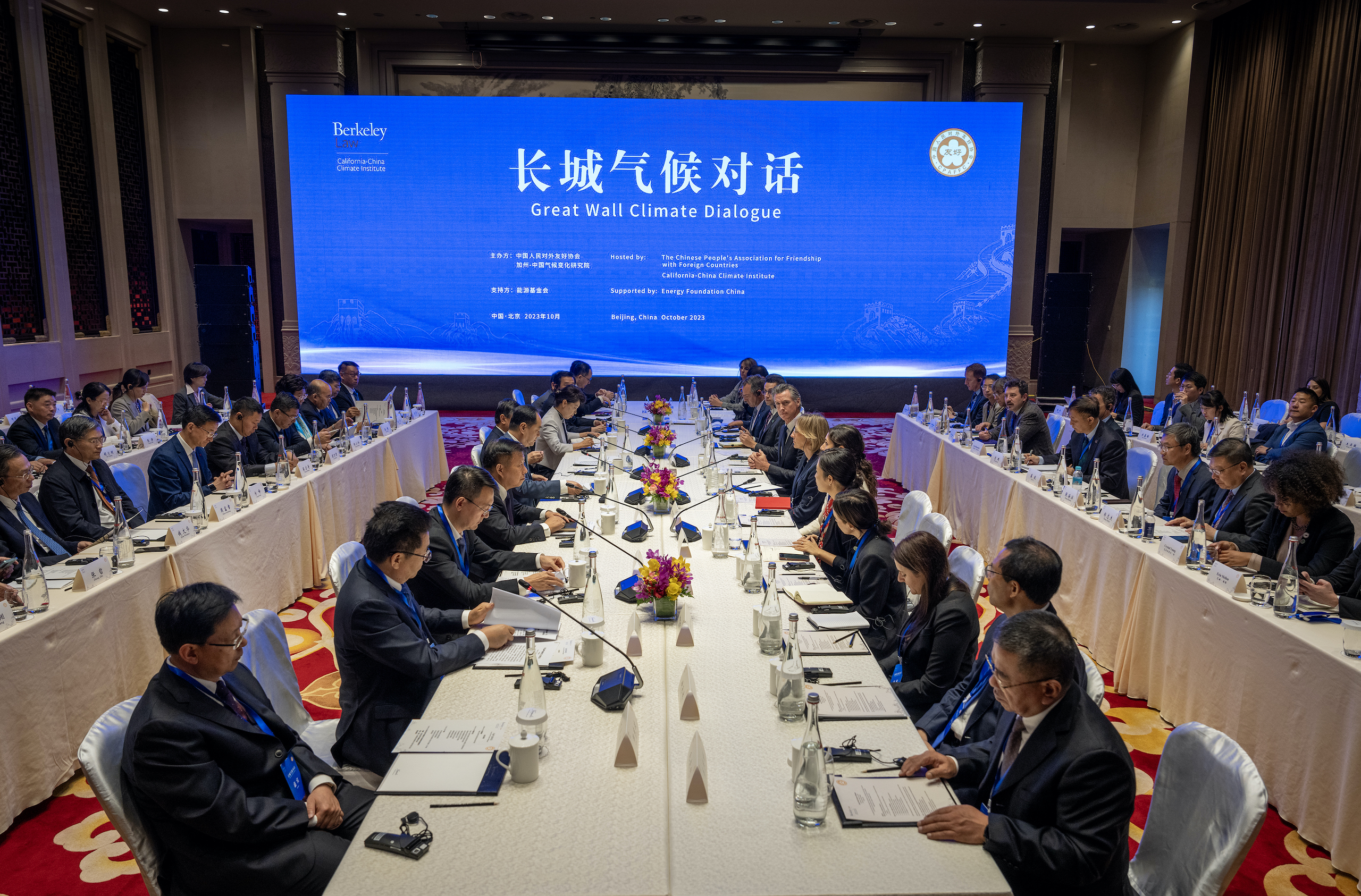 a group of people sitting at a long table for a meeting