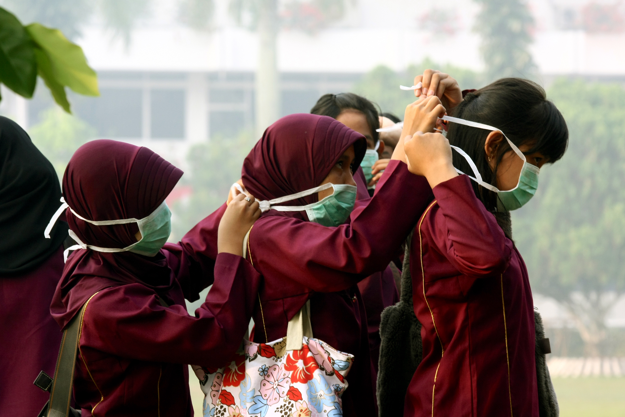 <p>Schoolchildren in Pekanbaru, western Indonesia, put on face masks to protect themselves from smoke caused by forest fires, lit to clear land for oil palm plantations. Photograph taken in 2009. (Image © Greenpeace / Oka Budhi)</p>
