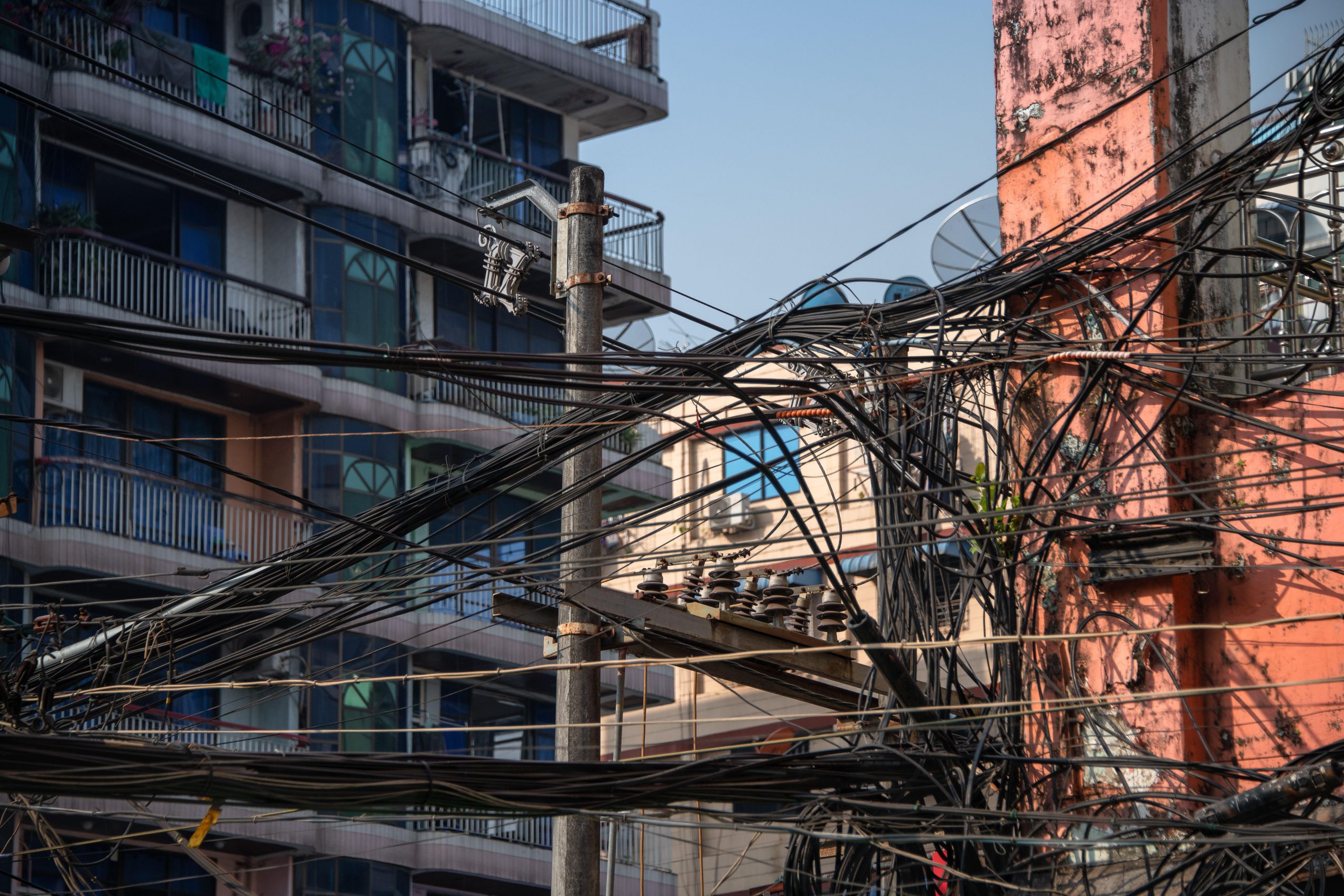 <p>A tangle of electrical wires connects city dwellers to the grid in Yangon, Myanmar (Image: Linda Kennard / Alamy)</p>