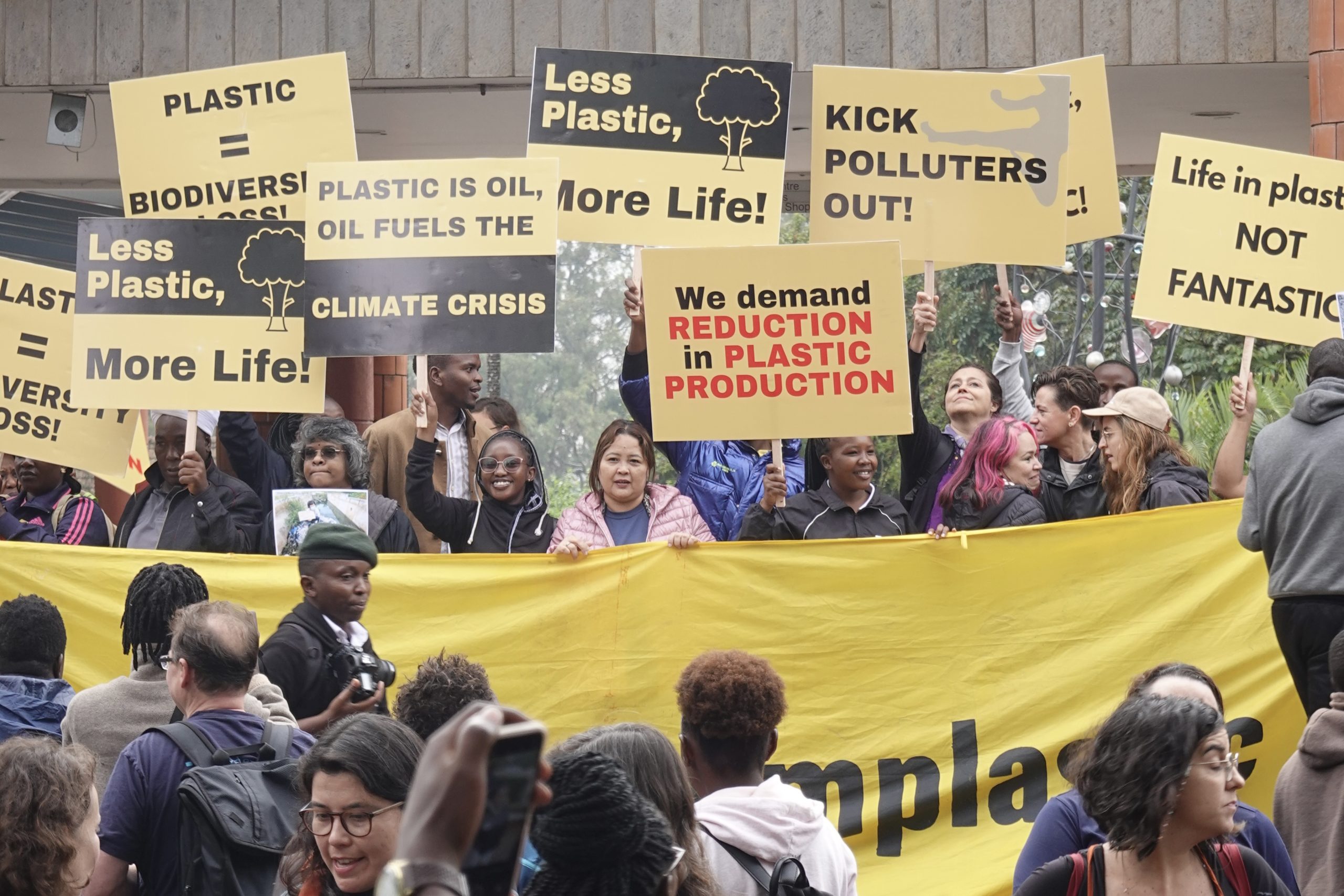 people holding up yellow protest placards and banners