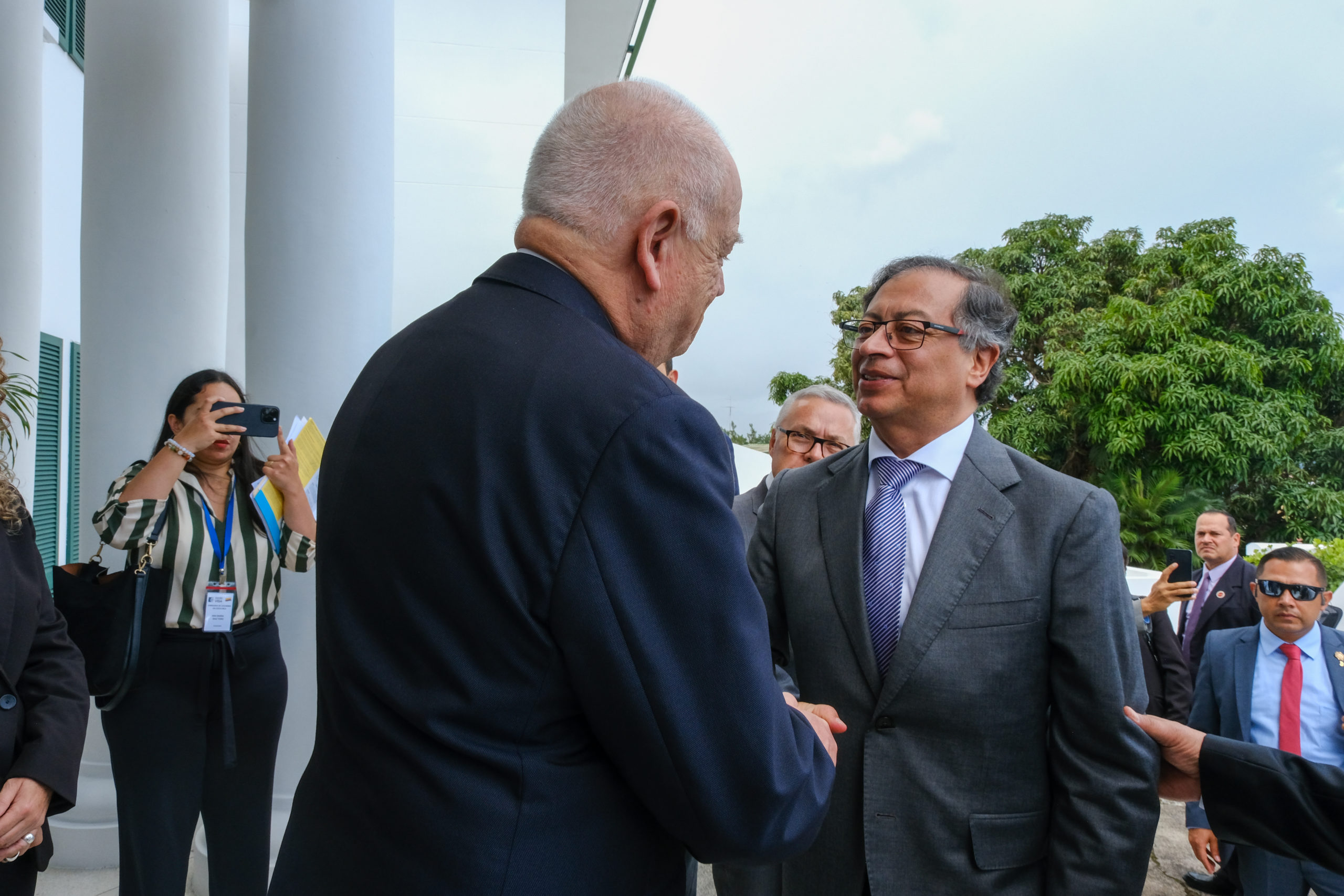 Gustavo Petro, presidente de Colombia, le da la mano a un hombre con un traje negro

