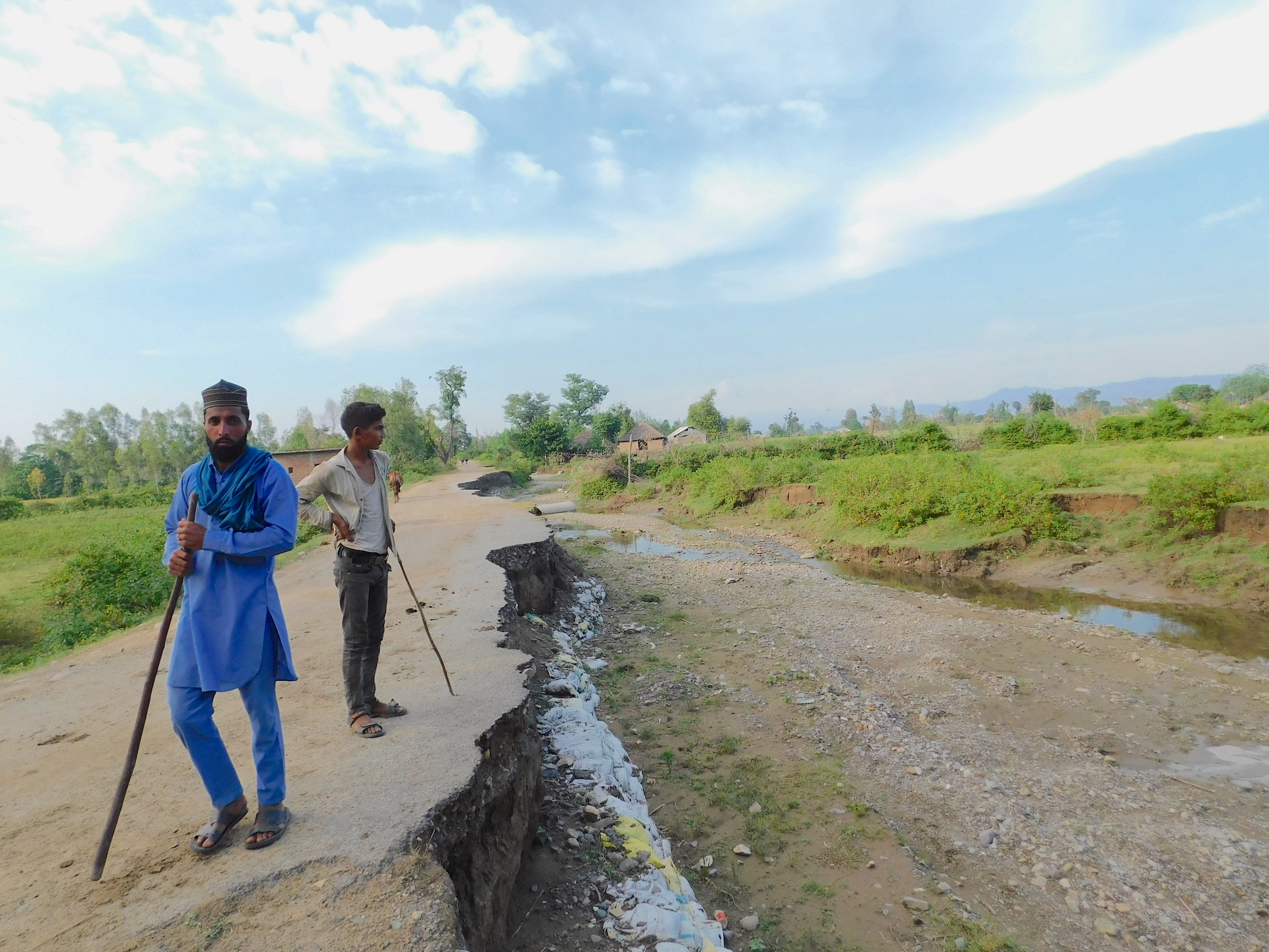 two men standing on a broken road