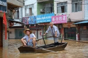 two people in a boat in a flooded area