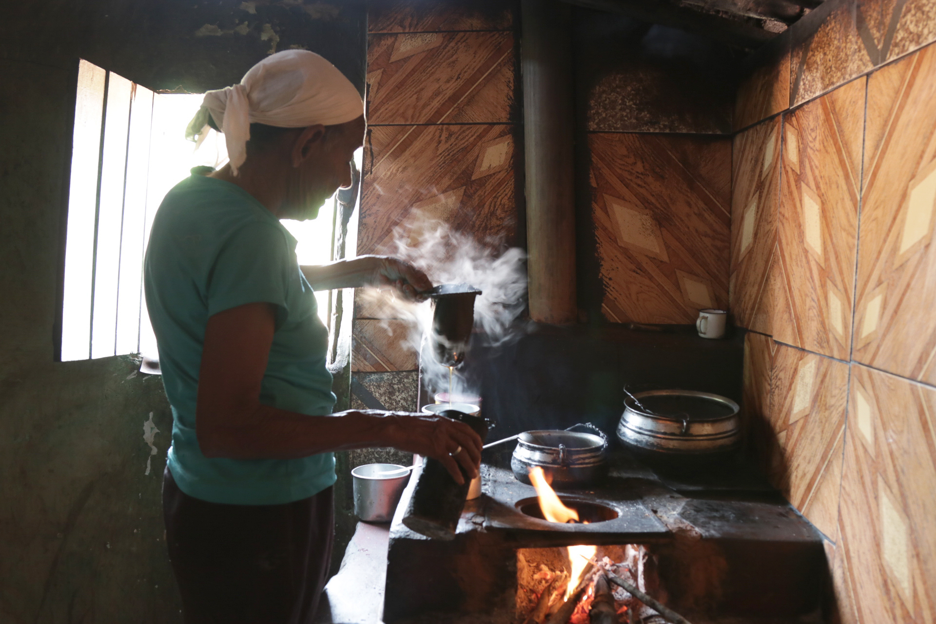 Mulher prepara café em um fogão a lenha na comunidade de Lamarão, no Vale das Cancelas
