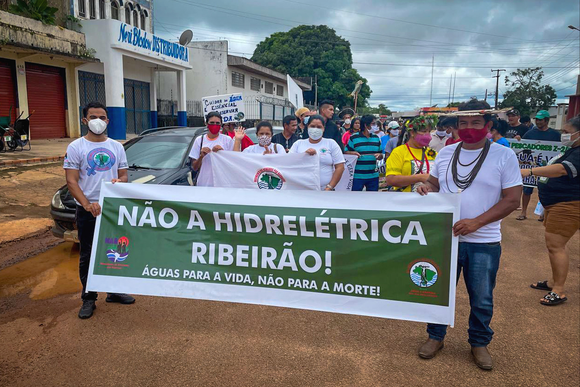 Pessoas marchando com cartazes e uma grande faixa