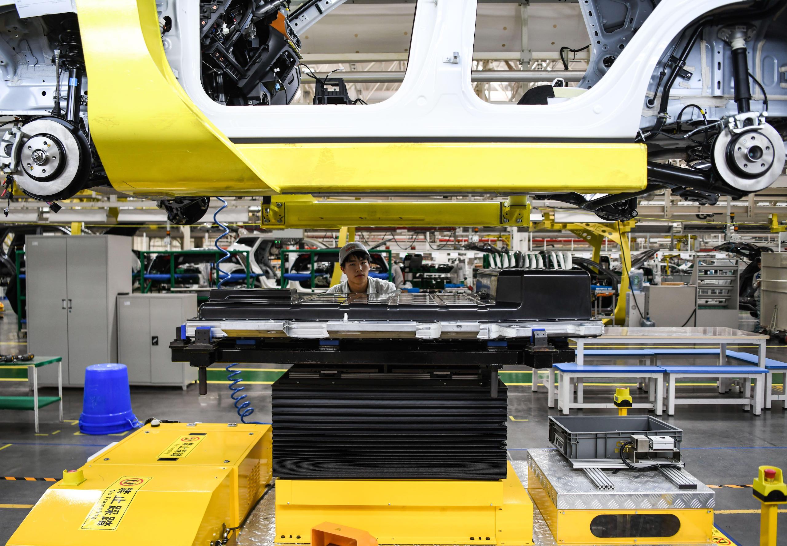 A technician installs batteries onto a new-energy vehicle