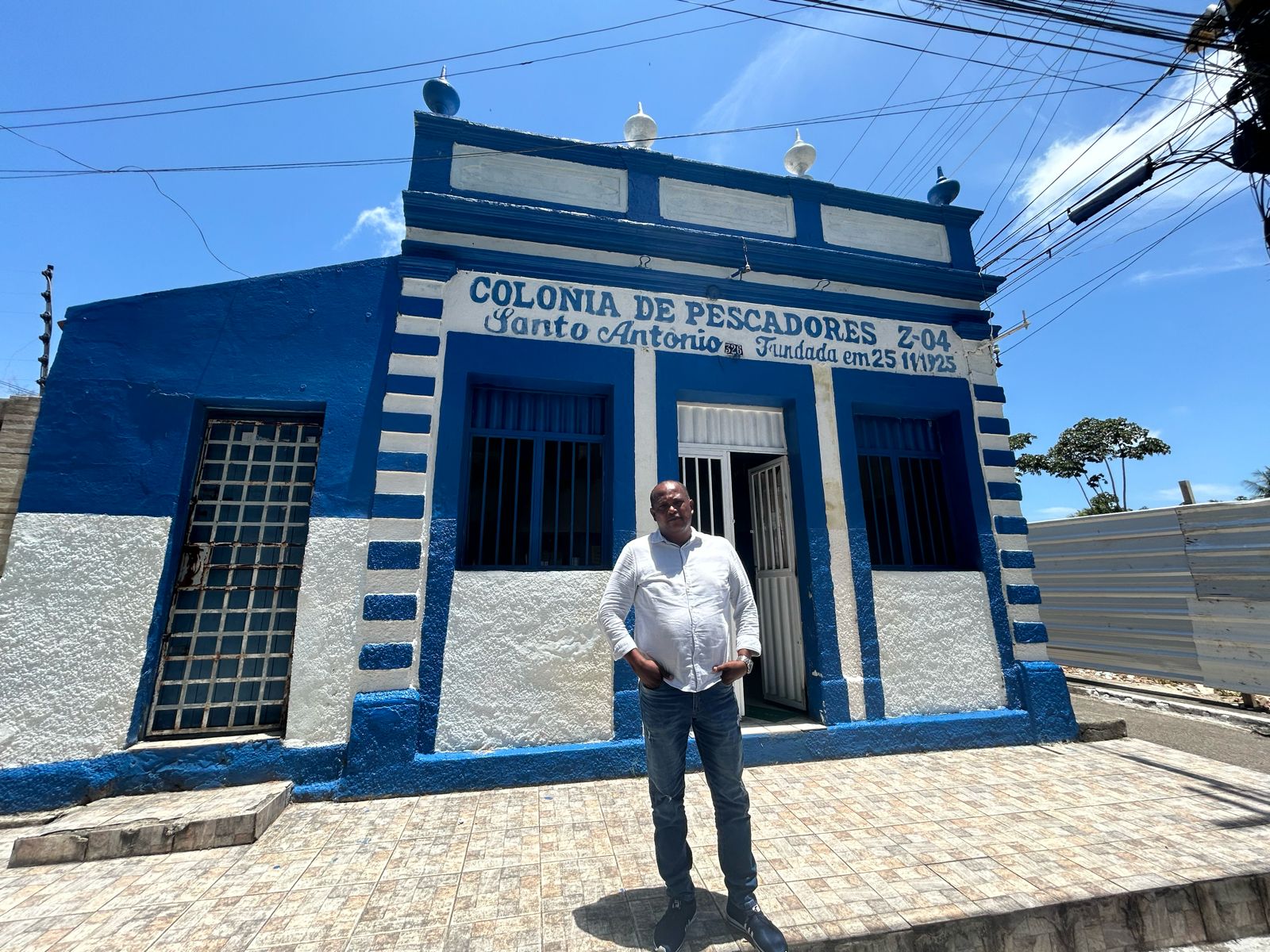 Un hombre parado en frente a un edificio blanco y azul