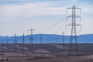 <p>Torres de transmissão de alta tensão no Deserto do Atacama, norte do Chile. Nova linha de 1.342 quilômetros deve conectar os parques de energia solar e eólica à rede do país (Imagem: Jon G. Fuller / Alamy)</p>