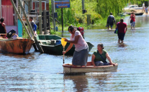 <p>Habitantes reman en una calle inundada en Villa Paranacito, provincia de Entre Ríos, Argentina, en 2016. Las ciudades situadas en el bajo río Uruguay sufren inundaciones recurrentes desde hace décadas. (Imagen: Alamy)</p>