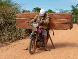 man on motorbike carrying timber