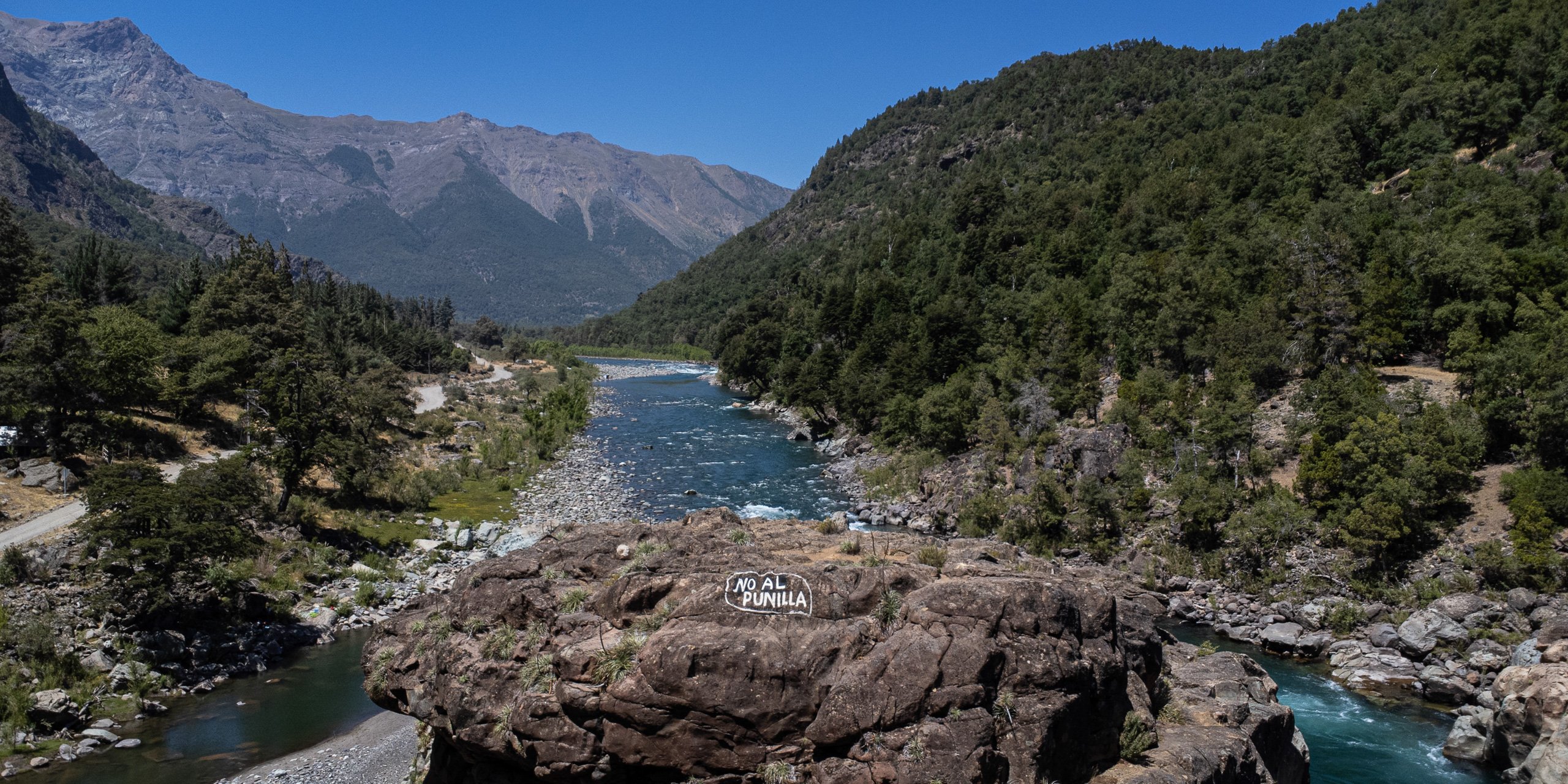 <p>En una roca del río Ñuble, cerca de San Fabián, Chile, se puede leer &#8216;No a Punilla&#8217;. El controvertido proyecto está paralizado desde 2021, pero el gobierno ha convocado una nueva licitación para su finalización (Imagen: Nicole Kramm / Dialogue Earth)</p>