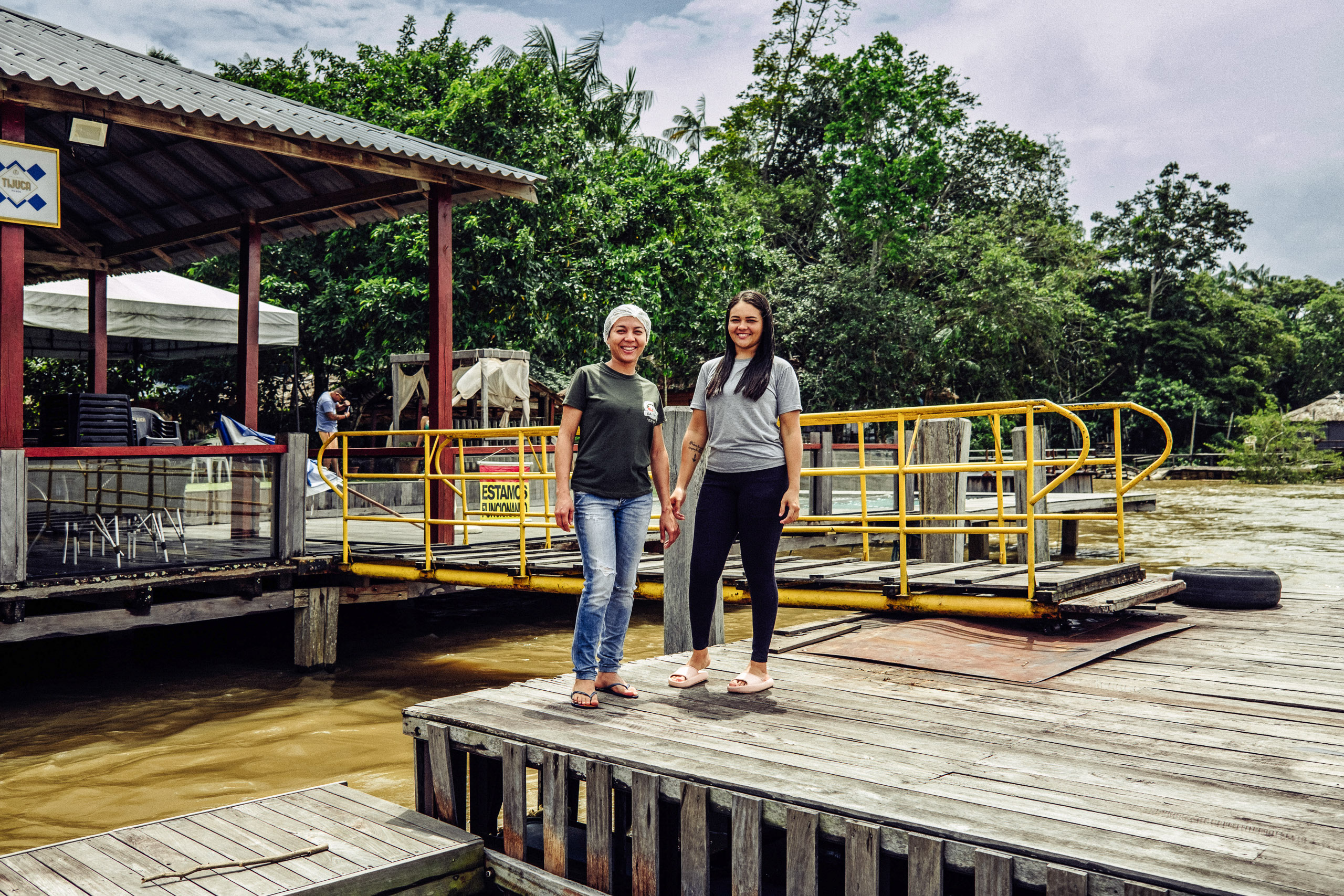 two women standing on river pier
