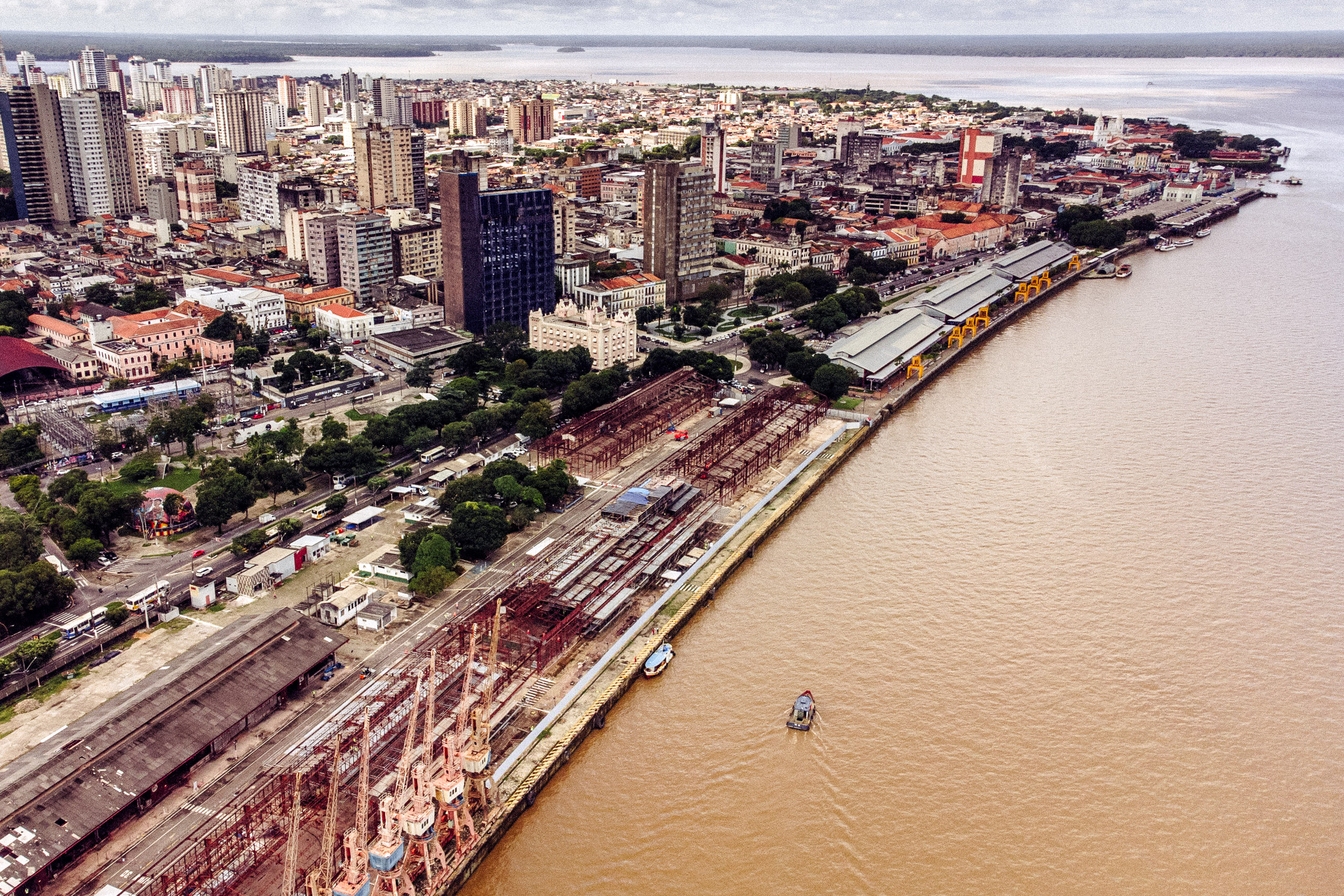 <p>Vista do porto de Belém e da Baía do Guajará, onde começou a construção da sede da COP30, o Porto Futuro. A cidade, no entanto, ainda luta para oferecer um ambiente saudável e serviços básicos para muitos dos seus 1,3 milhões de cidadãos (Imagem: Christian Braga / Dialogue Earth)</p>