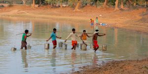 A group of mean fetching water from a lake