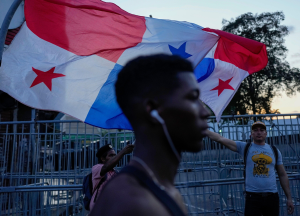 Un hombre con auriculares frente a una bandera de Panamá
