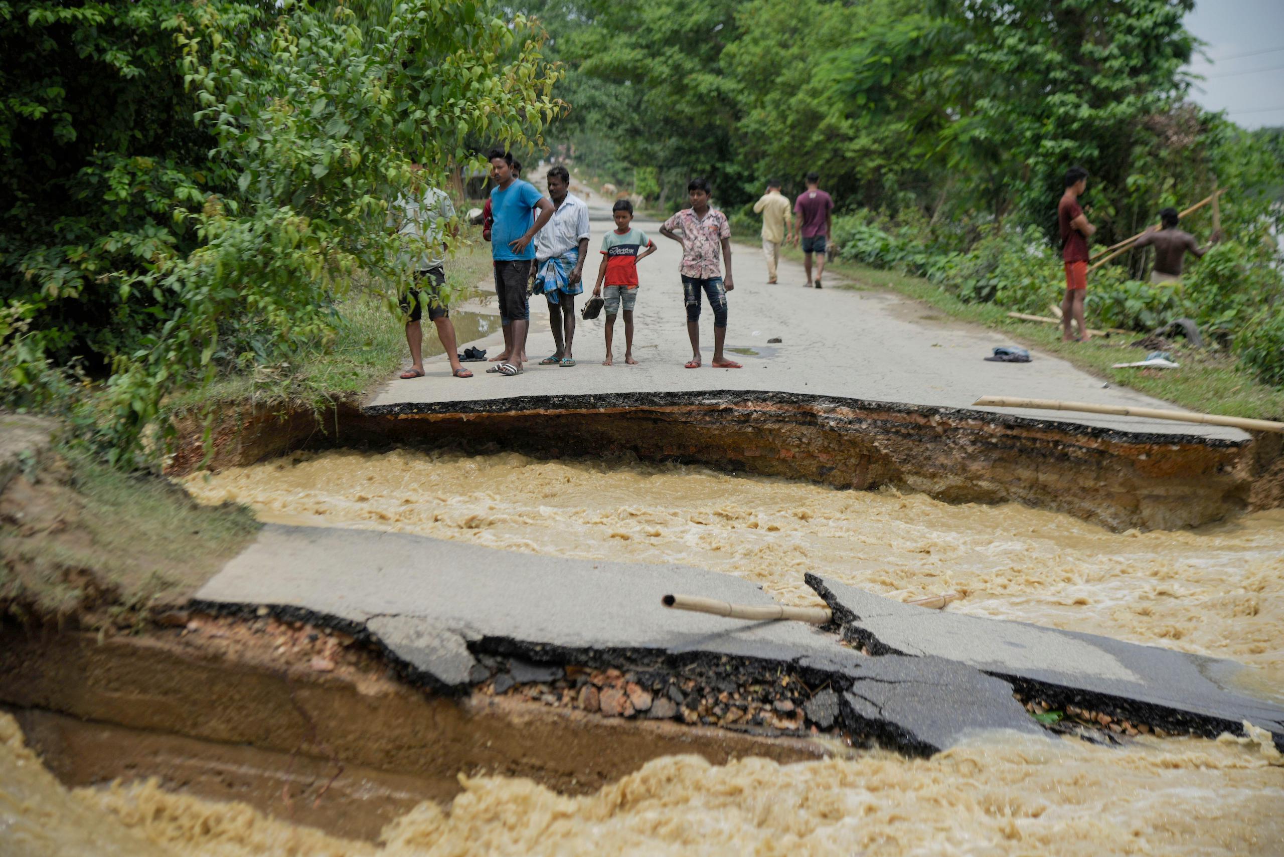 People standing near a damaged road