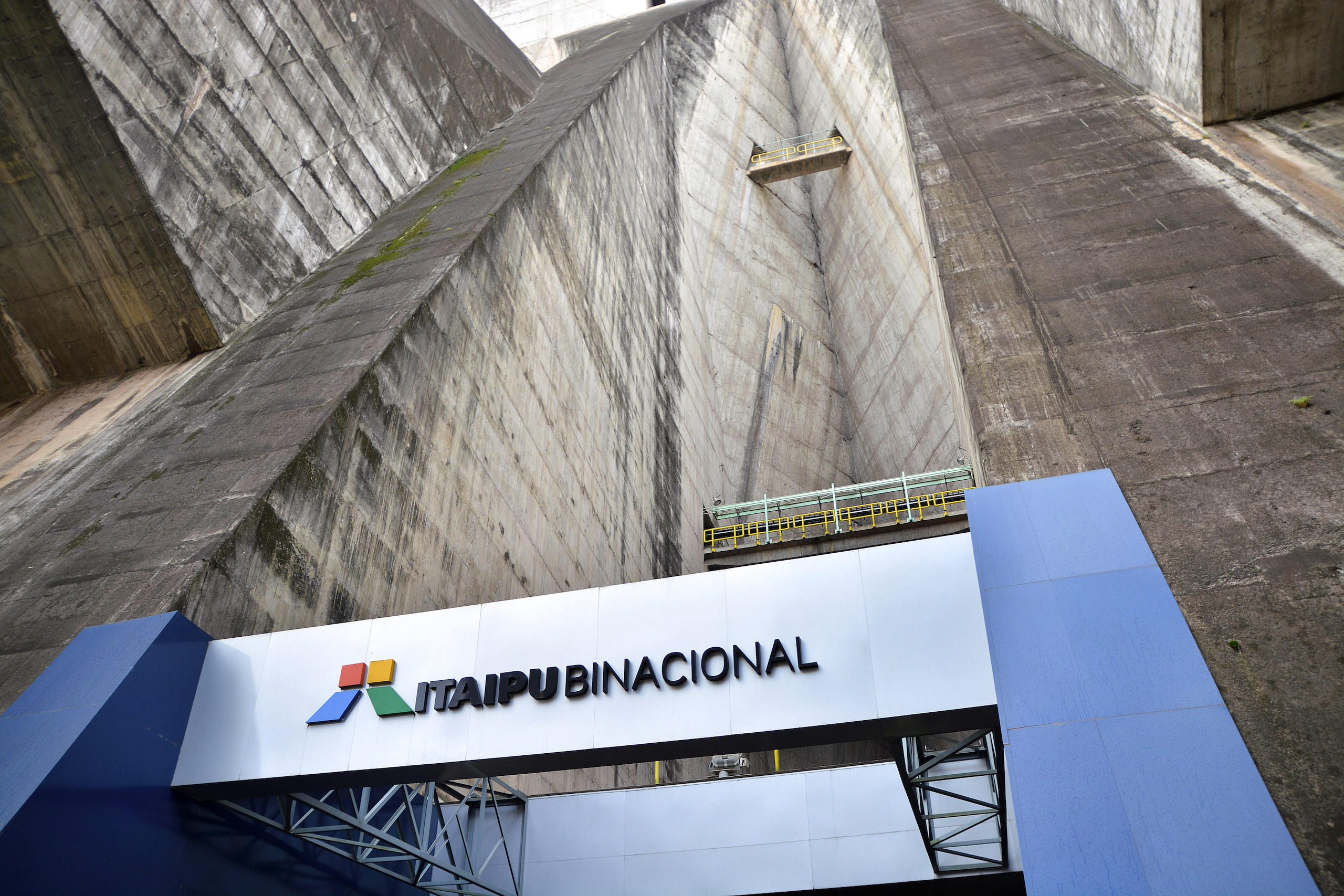Entrada a un enorme edificio de hormigón con un cartel en su entrada que dice "Itaipú binacional"