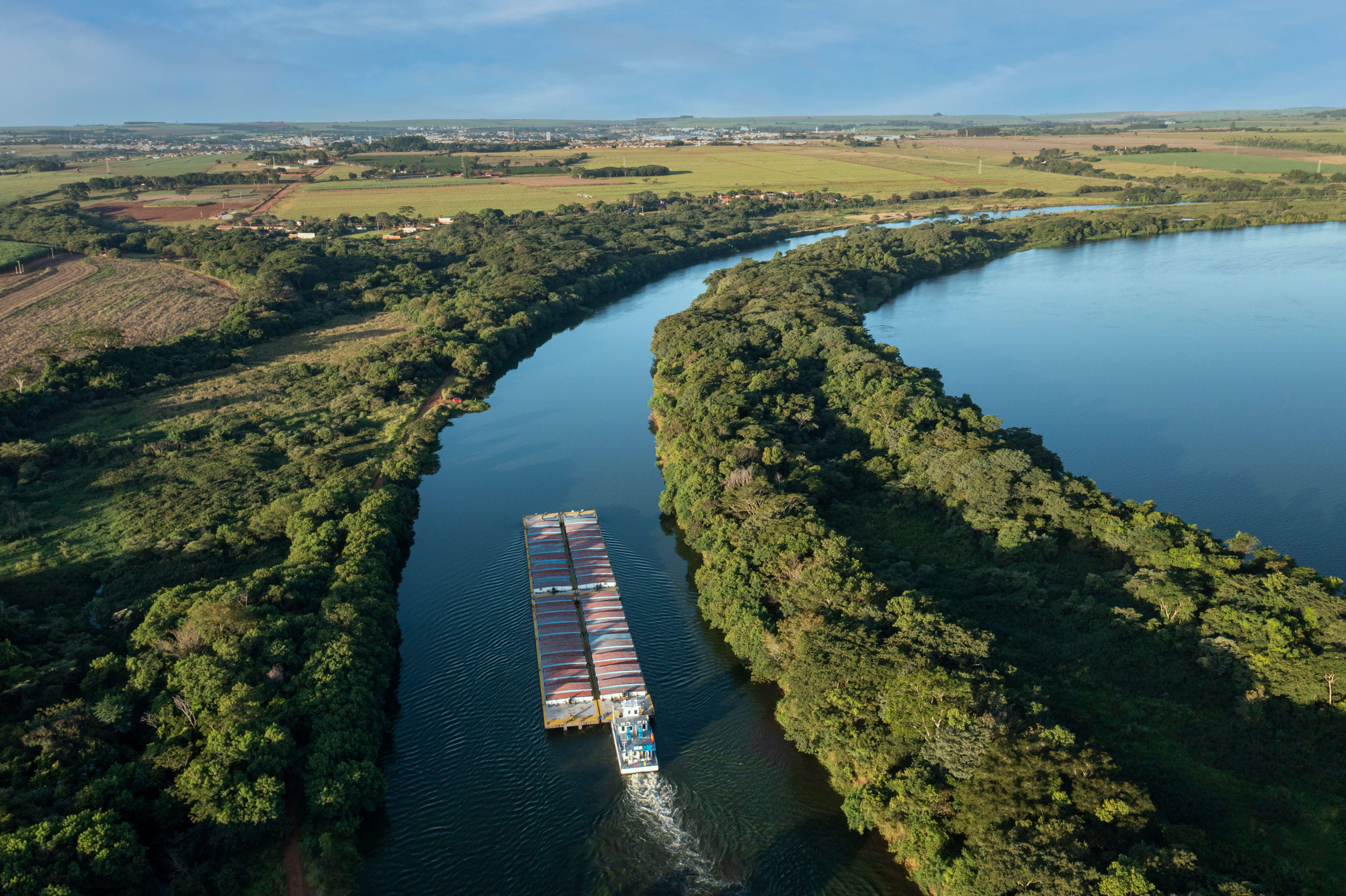 Aerial view of river barge travelling up waterway