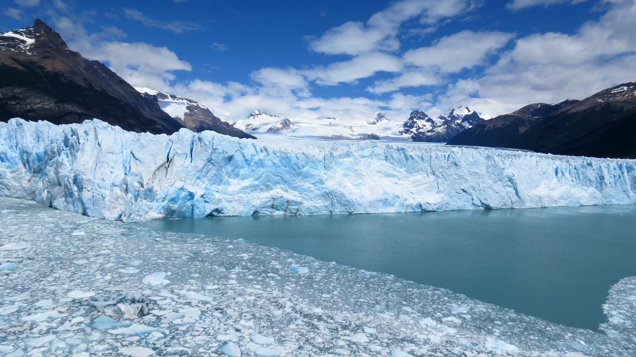 Un glaciar, con montañas nevadas de fondo