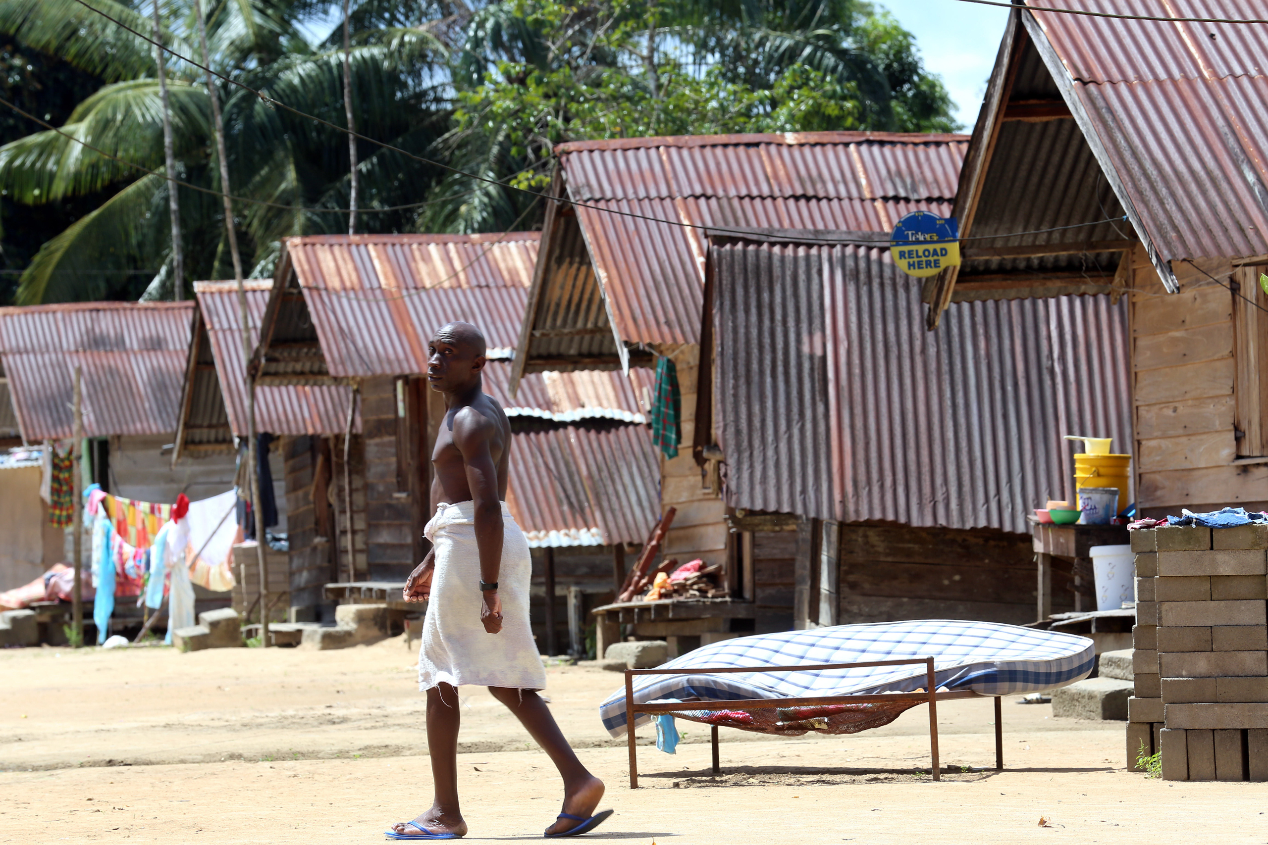 man walking through village