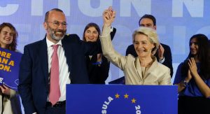 Manfred Weber and Ursula von der Leyen hold hands with arms raised