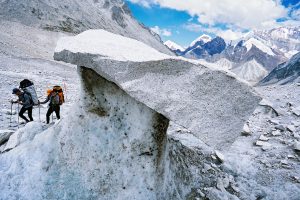 Two mountaineers passing a stone table