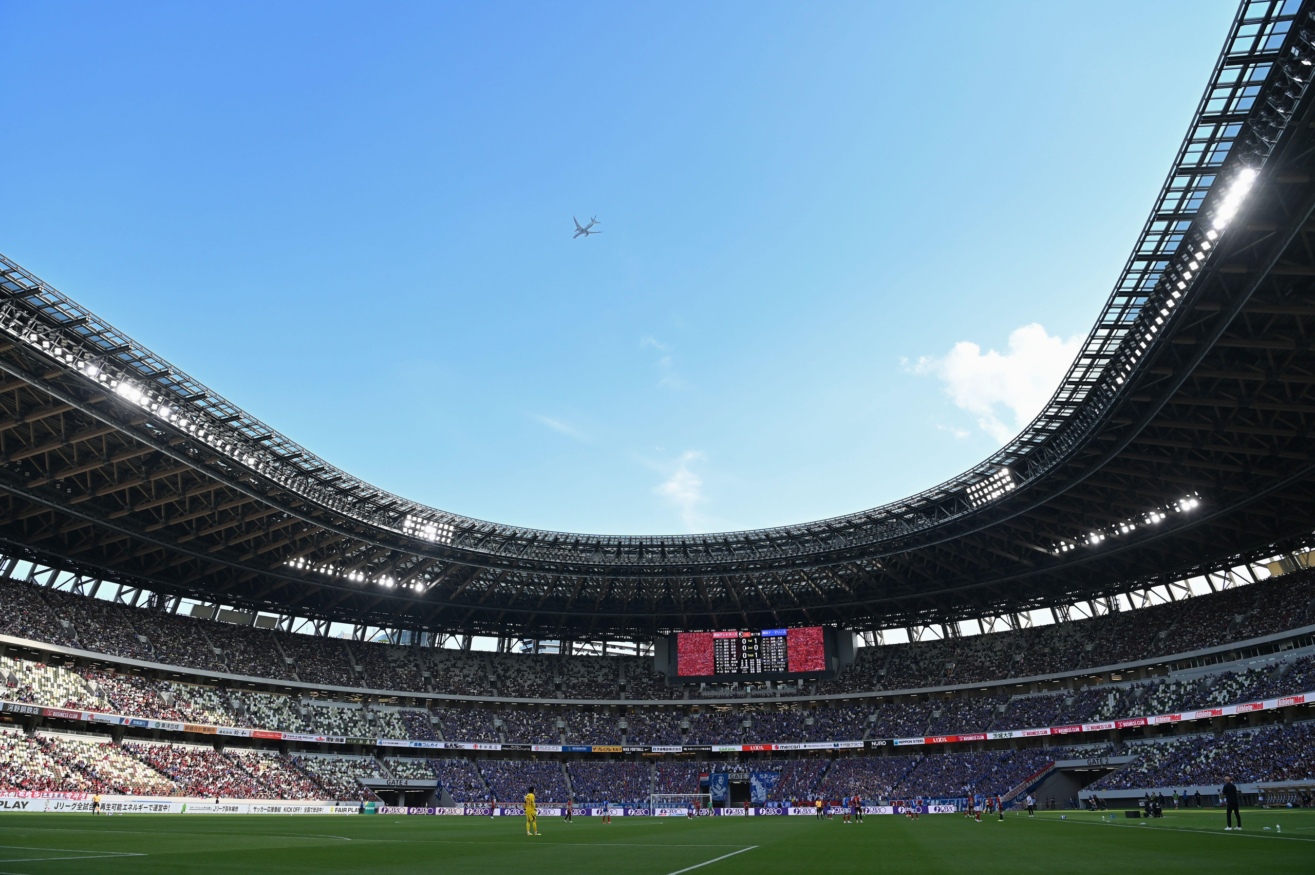 <p>Avião sobrevoa partida de futebol realizada em junho no Estádio Nacional do Japão, principal palco dos Jogos Olímpicos de Tóquio em 2020. As Olimpíadas de Paris e a Eurocopa deste ano anunciaram medidas para diminuir pegada de carbono (Imagem: AFLO / Alamy)</p>