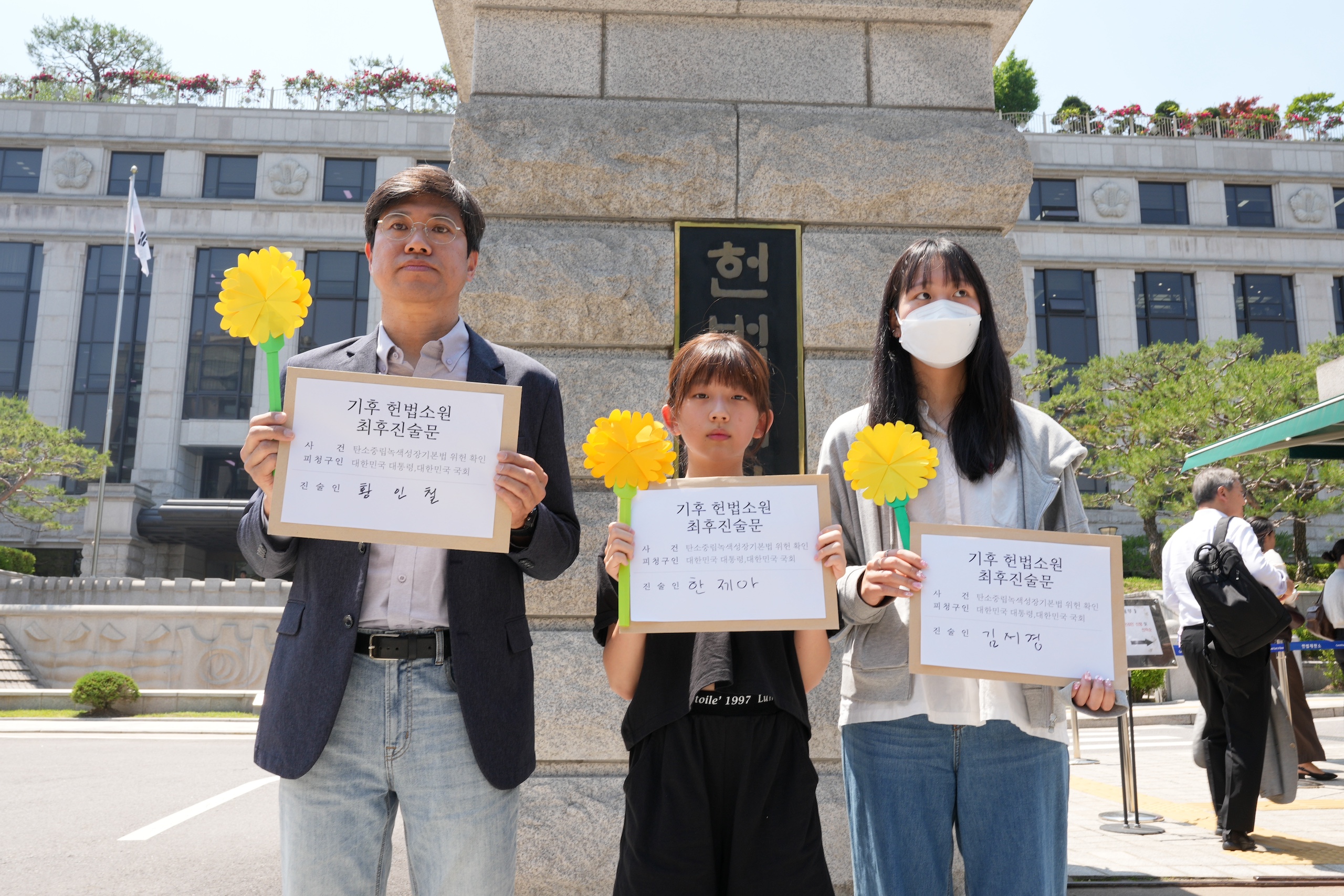 <p>12岁的韩济亚（中间）是此次起诉韩国政府的十九名年轻人之一，他们起诉韩国政府应对气候变化不力侵犯了自己的公民权利。图片来源：青年气候行动</p>