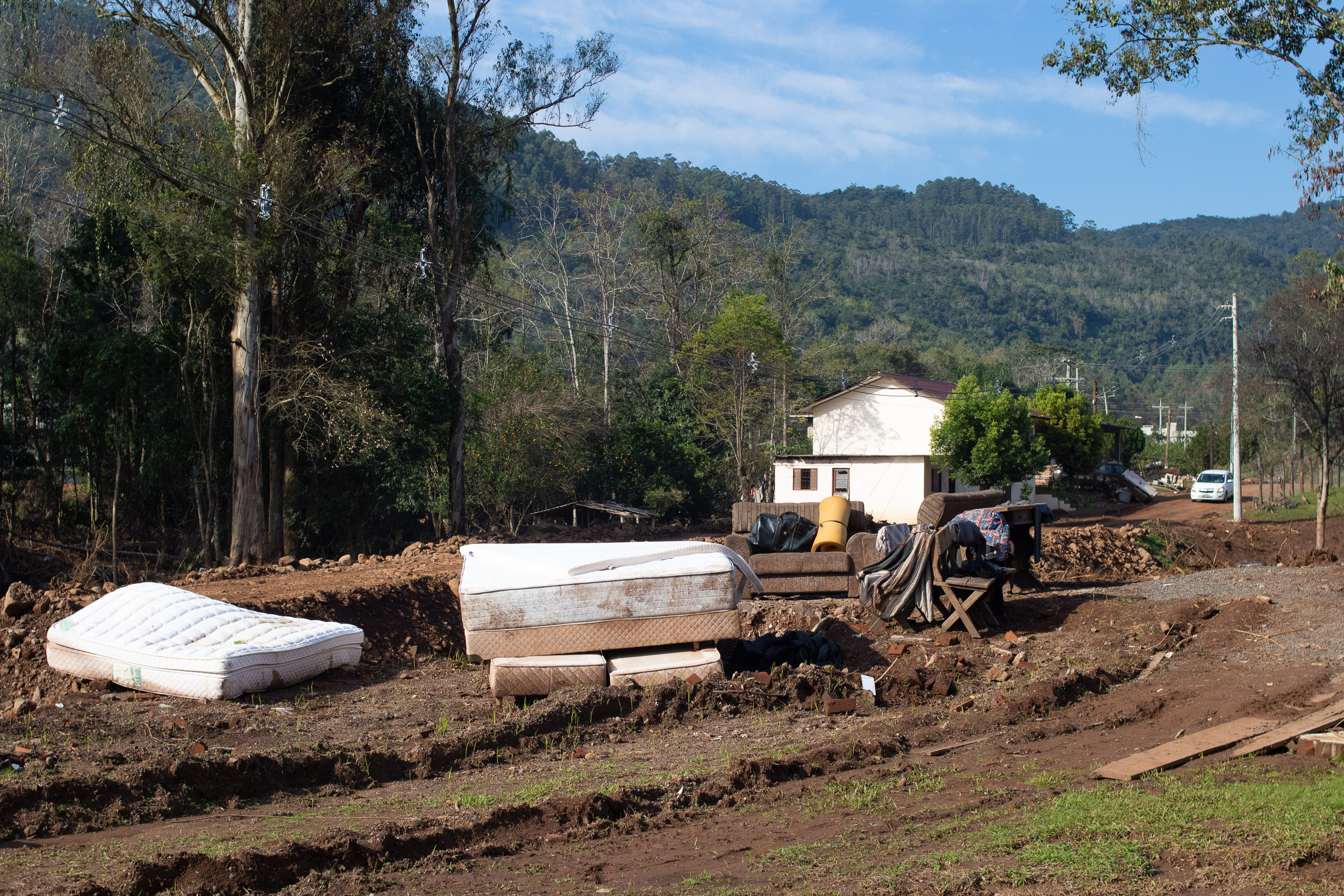 Colchões e móveis secam ao ar livre em Encantado.