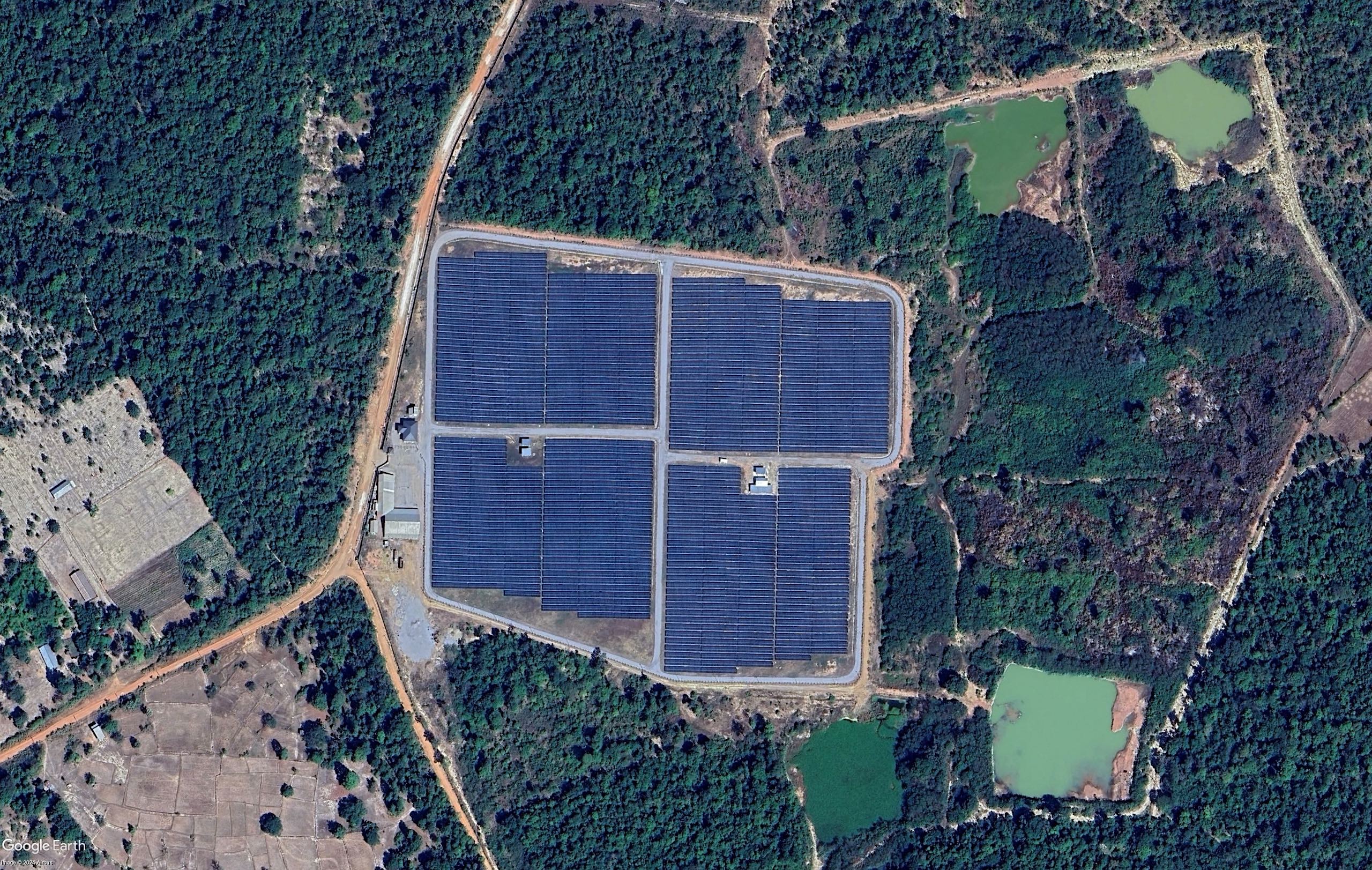 Aerial view of solar panels surrounded by trees