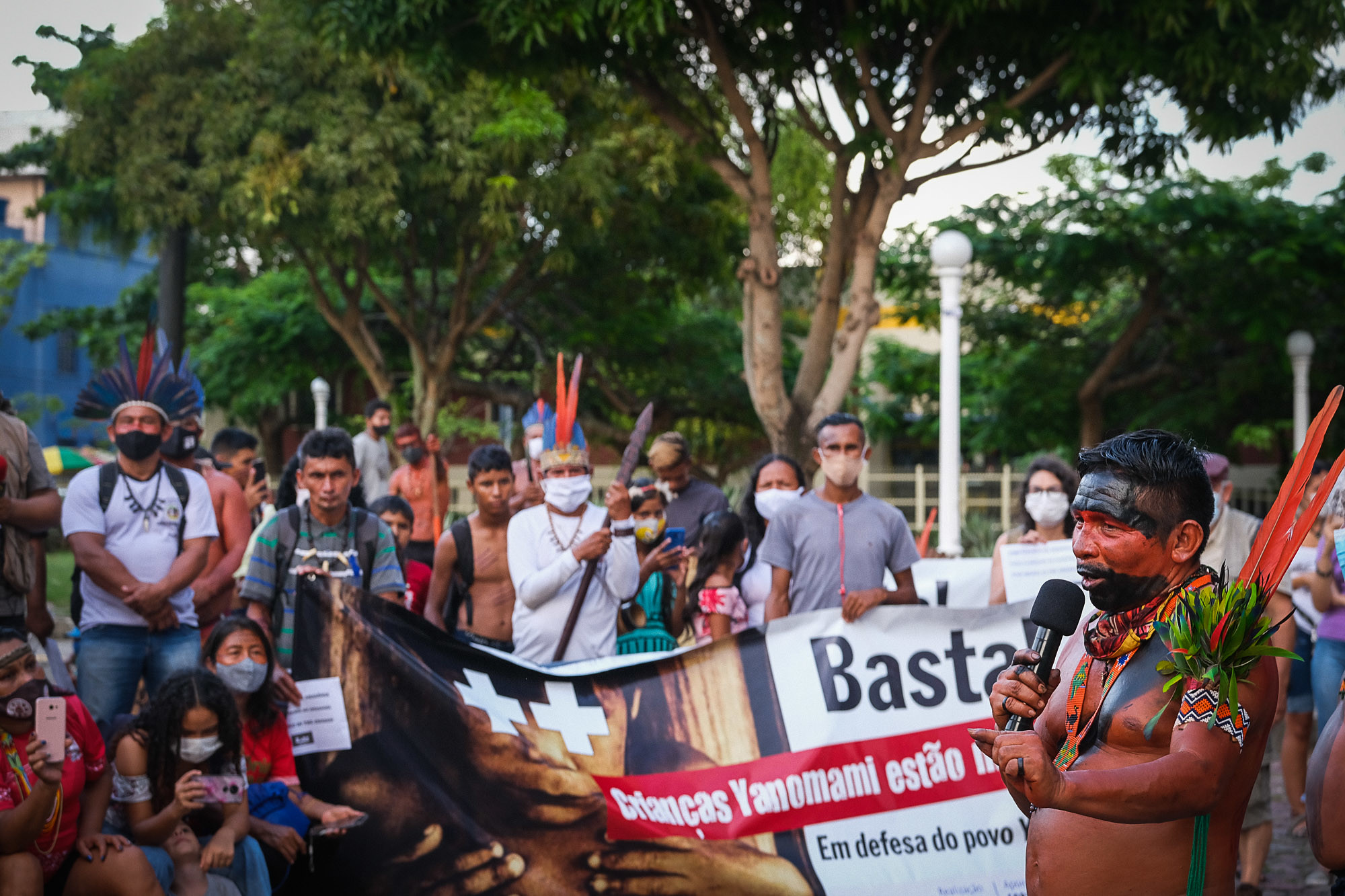 Un hombre habla por un micrófono ante una multitud en un acto de protesta