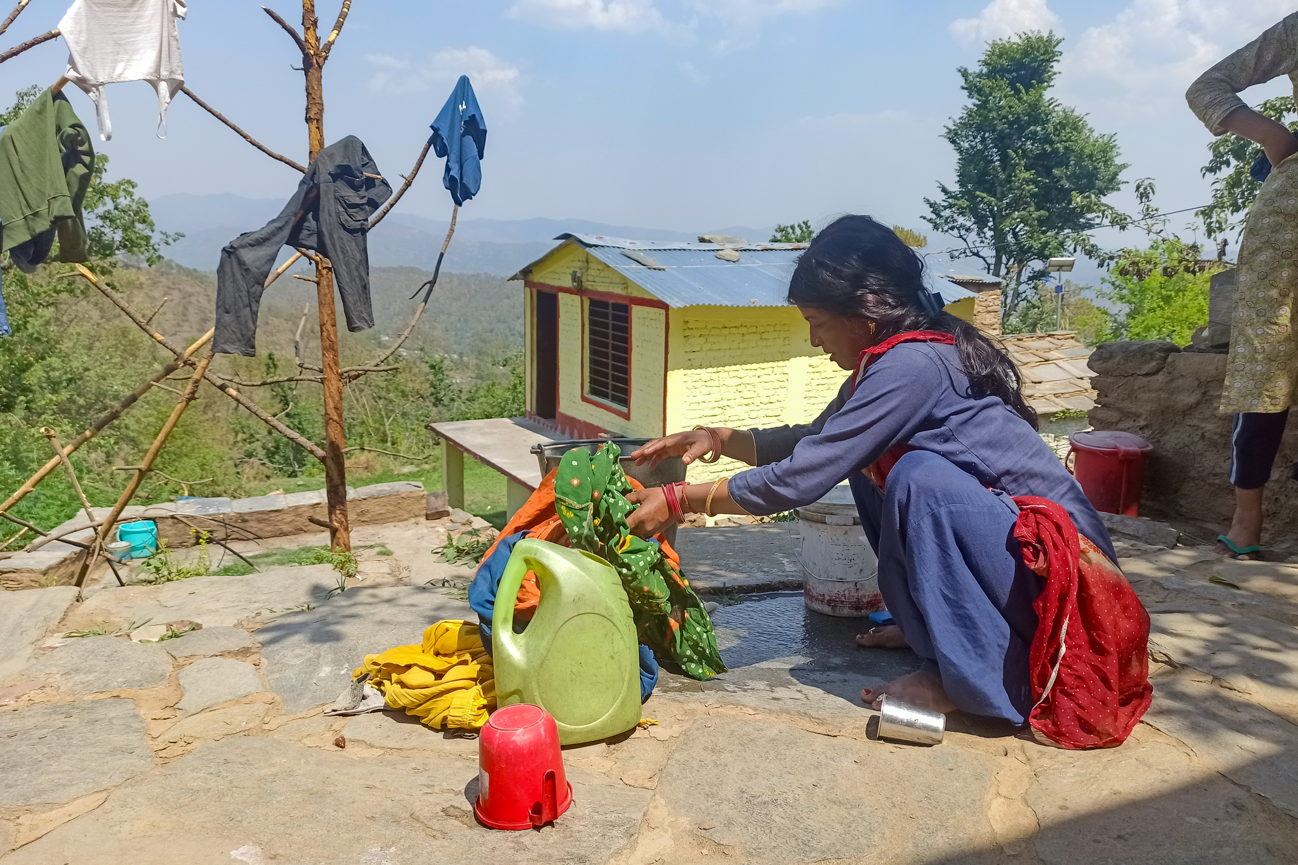 a woman washing clothes outside 