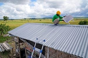 A man on a rooftop with solar panels