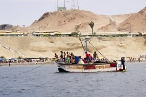 Un grupo de personas en un bote en una costa