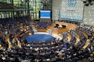 A crowded room with people sitting in chairs at the June UN Climate Meetings in Bonn, Germany.